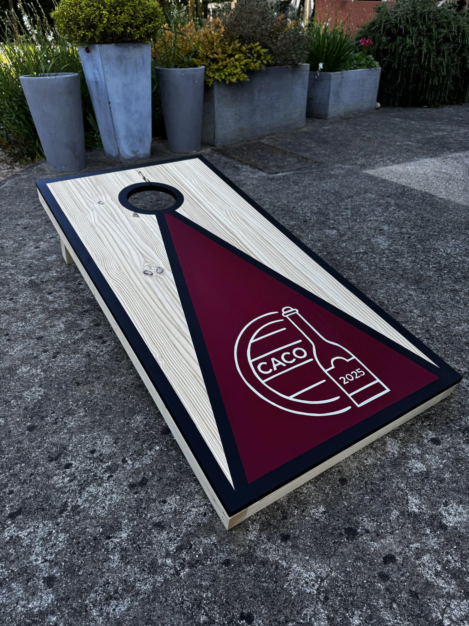 Cornhole personnalisé posé dans l’herbe